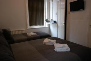 two beds in a small room with towels on them at Cardoh Lodge in Blackpool +63 photos