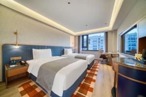 杭州的住宿－杭州萧山机场兰欧国际酒店，酒店客房设有两张床和大窗户。