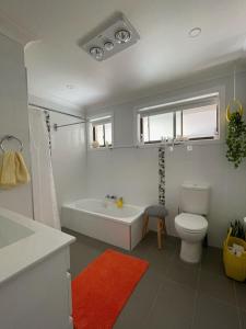 a bathroom with a tub and a toilet and a sink at Rocky in South West Rocks