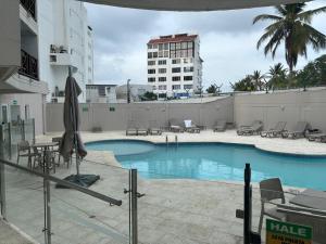 a swimming pool with chairs and an umbrella on a building at Hansa Reef - Espectacular Penthouse en San Andrés in San Andrés