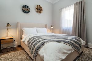 Un dormitorio con una cama grande y una ventana en Belle Escapes - Moseley Apartments near the beach with private garden en Glenelg