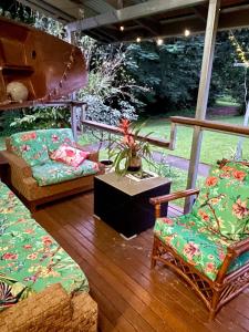 - une terrasse couverte avec des chaises, un canapé et une table dans l'établissement Babinda Quarters, à Babinda