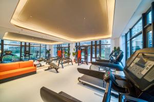 una oficina con un gimnasio con muebles y ventanas de color naranja en Hangzhou Xiaoshan Airport Lanou International Hotel en Hangzhou