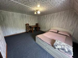 Un dormitorio con una cama y una mesa. en Комплекс Тимур en Taūtürgen