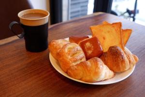 a plate of bread and croissants and a cup of coffee at HOTEL WAN OSAKA EBISU in Osaka