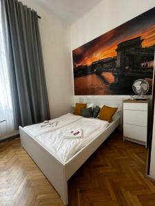 a bed in a room with a painting on the wall at Spring Roses Downtown Boutique Hotel 2 ON THE FAMOUS VÁCI FASHION STREET FREE COFFEE, TEE in Budapest