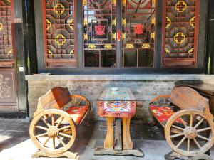 een tafel en twee okedokedokedoked bij Pingyao Harmony Hotel in Pingyao