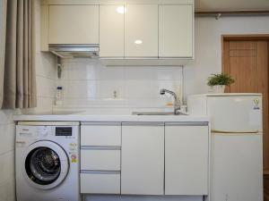 een keuken met een wasmachine en een koelkast bij Studio41 in Seoul
