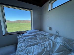 1 cama en un dormitorio con ventana grande en FLEXWORK tawa, en Shibecha