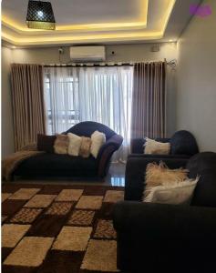 sala de estar con 2 sofás y sofá en The V Space, en Lusaka