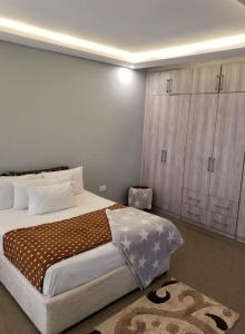 ein Schlafzimmer mit einem großen Bett und einem Schrank in der Unterkunft The V Space in Lusaka