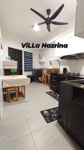 - un salon avec une table et un ventilateur de plafond dans l'établissement Villa Nazrina Homestay, à Sungai Petani