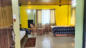 1 dormitorio con 1 cama, mesa y sillas en Bonobithikaloy Resort & Restaurant, en Chālsa Mahābāri