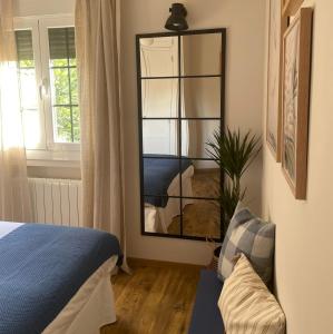 a bedroom with a mirror and a bed and a couch at Casa del Concejo in Segovia