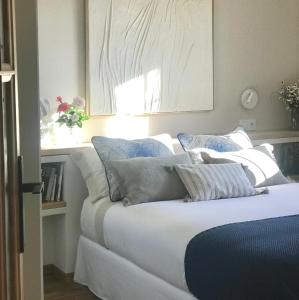 a bedroom with a bed with white and blue pillows at Casa del Concejo in Segovia