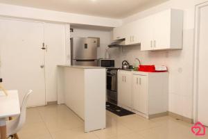 uma cozinha com armários brancos e um frigorífico em Departamento con vista de Lima em Lima