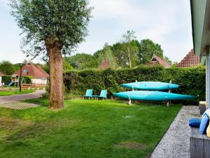 a group of blue boats sitting on the grass at Bungalow near De Alde Feanen with Boat in Earnewâld
