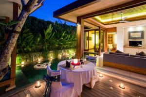 a patio with a table and a couch at Maca Villas & Spa Bali in Seminyak