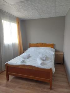 a bedroom with a bed with white sheets and pillows at Bluebell Cottage in Tsalka