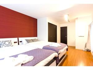 1 dormitorio con 2 camas y pared de madera en Gracias Shibuya Honmachi - Vacation STAY 81716v en Tokio