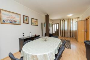 une salle à manger avec une table et des chaises blanches dans l'établissement Hotel Fobra, à Podgorica