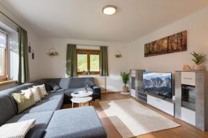 a living room with a couch and a tv at Bauernhof Unterstegen in Söll