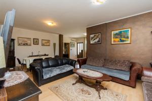 sala de estar con sofá de cuero y mesa en Hotel Fobra en Podgorica