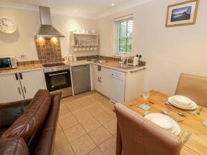 a kitchen and living room with a table and a couch at Tregonning Lodge in Helston