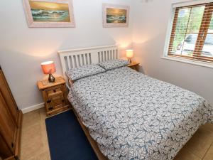 - une chambre avec un lit et une fenêtre dans l'établissement Tregonning Lodge, à Helston