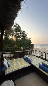 Bett mit Kissen auf einem Balkon mit Meerblick in der Unterkunft SaffronStays Stella Maris - Luxury Beach Front Villa Near Redi Beach in Querim