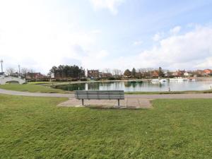 a park bench sitting next to a body of water at Cozzzy Seaside Retreat in Mablethorpe