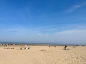 a group of people standing on a beach at Cozzzy Seaside Retreat in Mablethorpe