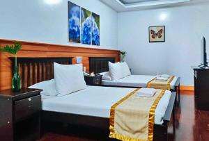 a hotel room with two beds and a tv at RedDoorz at Nick Hotel Isabela 