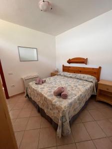 Un dormitorio con una cama con toallas rosas. en casa donatella, en Cala Liberotto