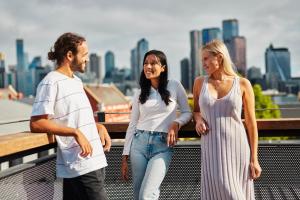 een groep van drie mensen die op een brug staan bij The Village North Melbourne in Melbourne