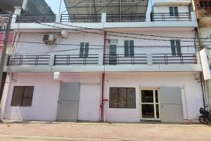 ein weißes Gebäude mit Balkon darüber in der Unterkunft Hotel Blossom in Lucknow