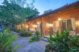 una casa de ladrillo con un patio con plantas en Taman Bidadari wellness & Retreat, en Banyuwedang