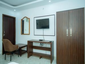 Zimmer mit einem Schreibtisch, einem Stuhl und einem Spiegel in der Unterkunft Hotel Blossom in Lucknow