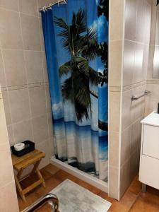 uma casa de banho com uma cortina de chuveiro com uma palmeira em apartamento hans em San Antonio