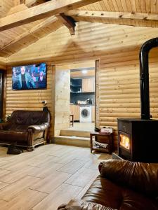 uma sala de estar com mobiliário de couro e uma televisão de ecrã plano em Къща за гости Виевци em Vievo