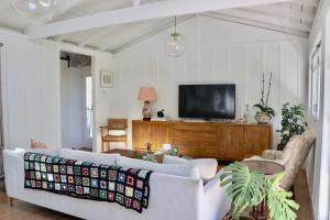a living room with a couch and a tv at The Moreporks Cottage in Ostend