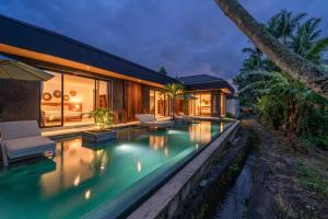 uma casa com uma piscina em frente em Villa Surga - 4BR Heavenly Ricefields View Villa in Ubud em Ubud