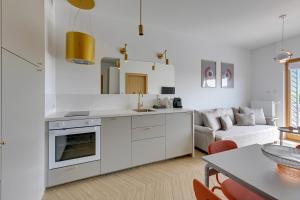 uma cozinha e sala de estar com paredes brancas em Apartament Gdańsk My Way by TriApart em Gdansk