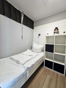 a small bedroom with a bed and a shelf at Bellevue B4 in Großenbrode