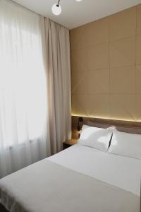 文尼察的住宿－Duboviy Gai Hotel，卧室配有白色的床和窗户。