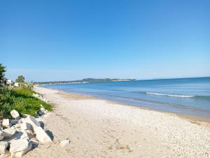 a beach with rocks and the ocean on a sunny day at Voula's maisonette in Acharavi