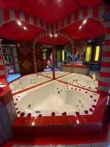 eine Whirlpool-Badewanne in einem Zimmer mit roten Fliesen in der Unterkunft Hotel Boutique El Duende Mantagua in Quintero