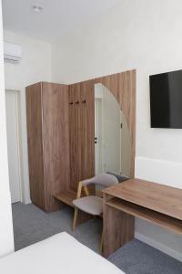 een kamer met een spiegel, een bureau en een televisie bij Duboviy Gai Hotel in Vinnytsya