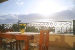 una mesa con sillas y un jarrón de flores en el balcón en Golden Sands-Beachfront apartment of your dreams, en Golden Sands