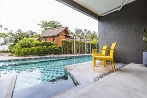 a yellow chair sitting next to a swimming pool at Anyavee Krabi Beach Resort formerly known as Bann Chom Le Beach Resort in Klong Muang Beach